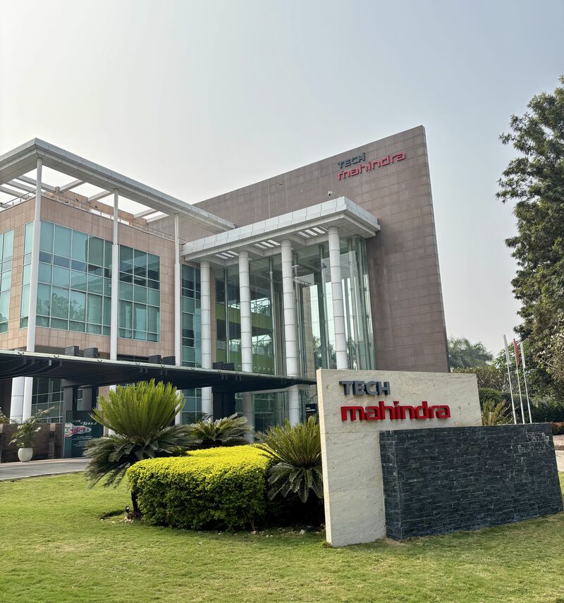 Four tall exterior circular steel columns at the Tech Mahindra building in Hinjewadi